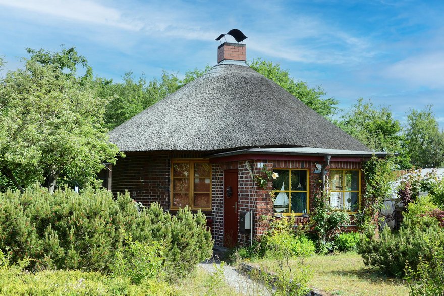 zeigt rundes Haus aus Klinkermauerwerk und mit Schilfdach